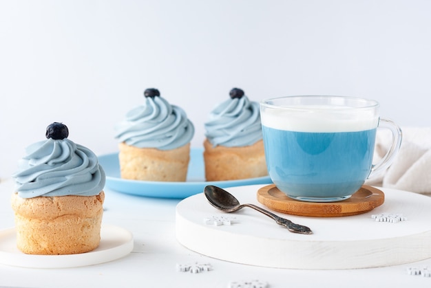 Bebida de moda azul de té de guisantes de mariposa con espuma de leche y pastel para el desayuno