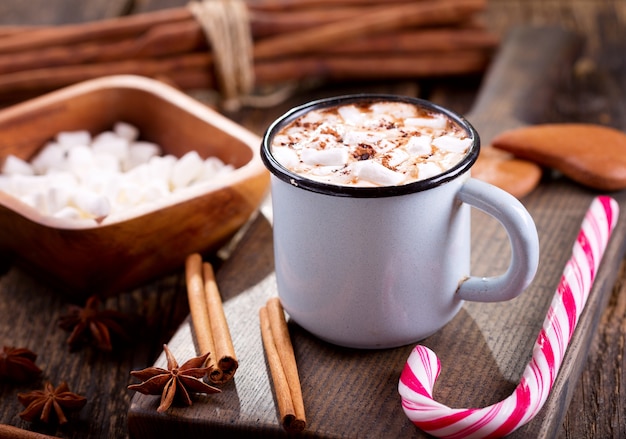 Bebida navideña. Taza de chocolate caliente con malvaviscos en mesa de madera