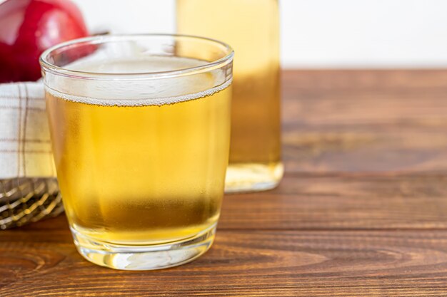 Bebida orgánica saludable. Sidra de manzana en un vaso y manzanas rojas frescas.