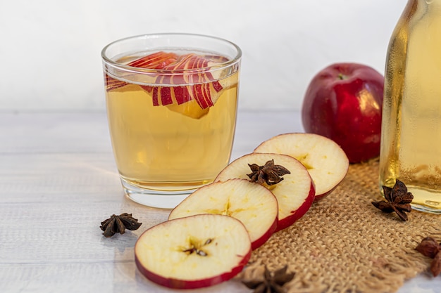 Bebida orgânica saudável. Sidra de maçã em um copo e maçãs vermelhas frescas.