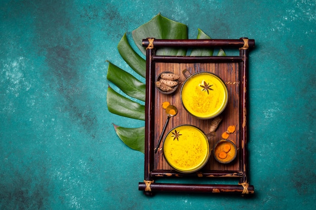 Bebida quente com leite dourado açafrão com leite com curcuma em pó e especiarias. Vista do topo.