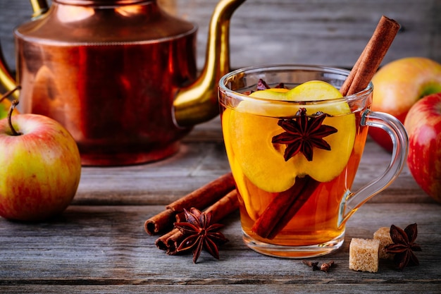 Bebida quente de cidra de maçã quente com cravo de canela e anis em fundo de madeira