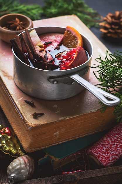 Bebida quente de vinho quente com frutas cítricas, maçã, romã e especiarias