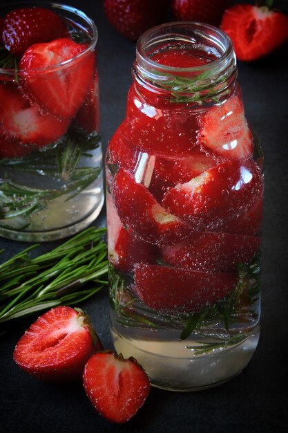 Bebida refrescante de agua mineral con fresas y romero