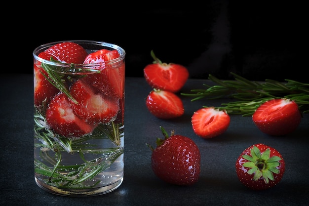 Bebida refrescante de agua mineral con fresas y romero