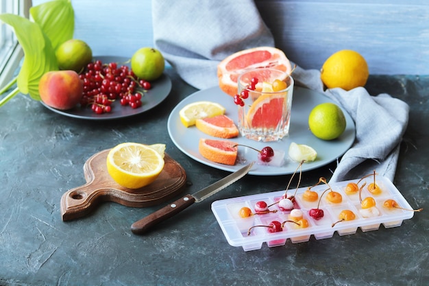 Bebida refrescante de cítricos, bayas, hojas de menta y hielo sobre la mesa, cócteles caseros