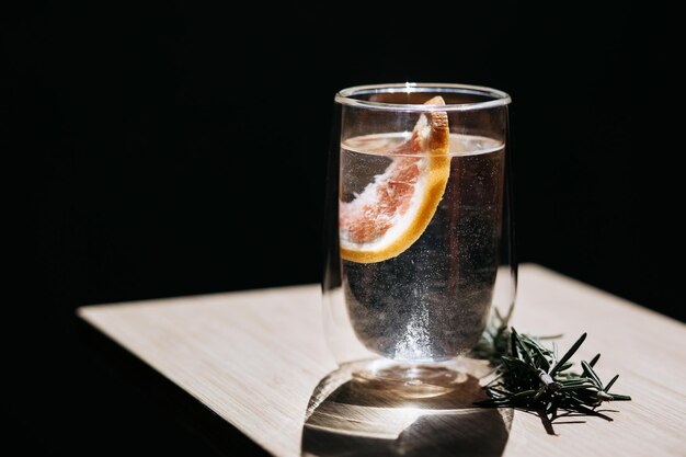 Bebida refrescante com laranja ao sol sobre um fundo preto