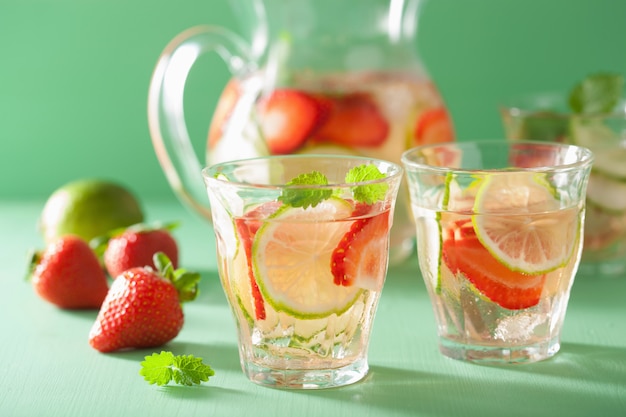 Bebida refrescante de verão com limão pepino morango na jarra e copos