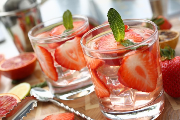 Bebida refrescante de verão com pedaços de morango em copos na cozinha