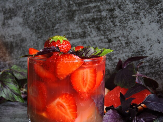 Bebida refrescante de desintoxicación para bajar de peso con fresas, pomelo y albahaca azul.