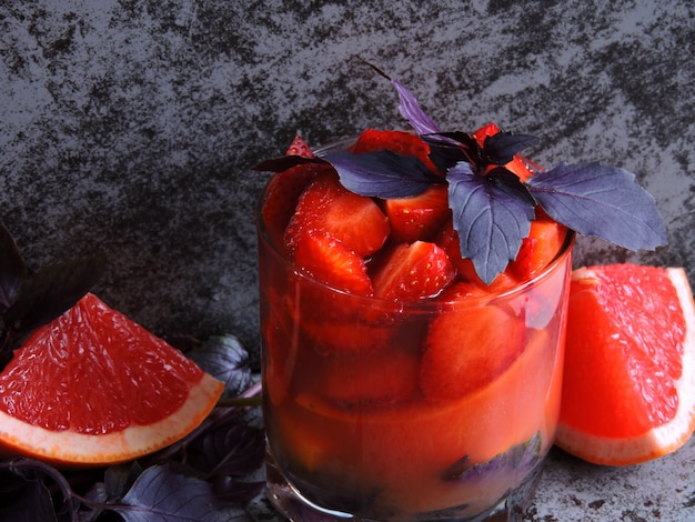 Bebida refrescante de desintoxicación para bajar de peso con fresas, pomelo y albahaca azul.