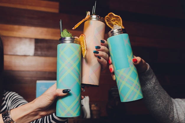Una bebida refrescante se encuentra en una mesa con un termo de frutas y menta.