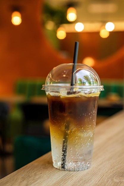 Bebida refrescante helada con tónico espresso en un vaso para llevar en una cafetería