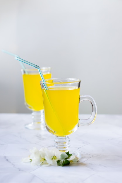 Bebida refrescante de limonada en un vaso de vidrio sobre un fondo claro