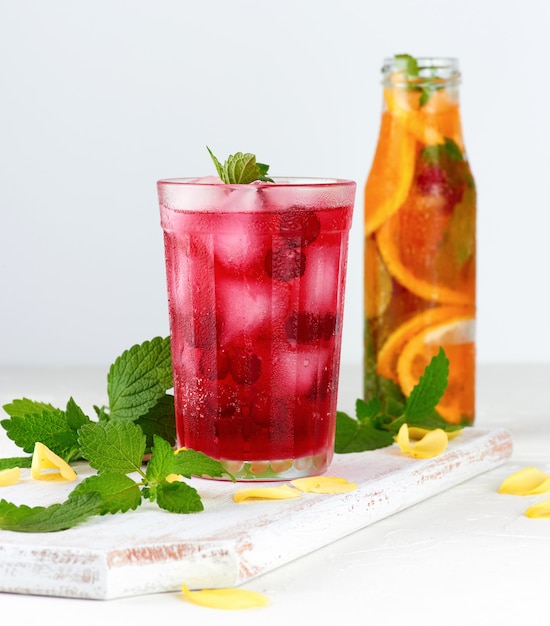 Bebida refrescante de verano con bayas de arándanos y trozos de hielo en un vaso