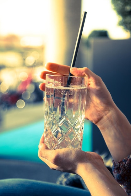 Bebida refrescante en verano La chica sostiene un vaso con una bebida fría