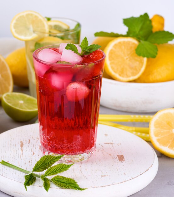 Bebida refrescante de verano de fresas y arándanos en una tabla de madera blanca
