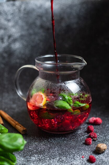 Bebida roja fresca frambuesa bayas albahaca verde menta bebida cóctel o té hielo frío