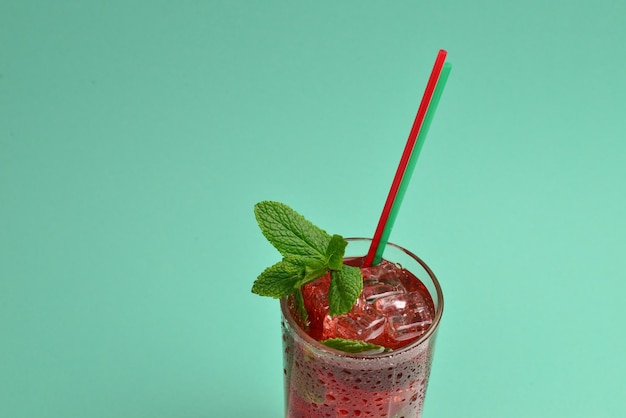 Foto bebida roja fresca con pomelo helado y menta sobre un fondo verde espacio para texto o diseño