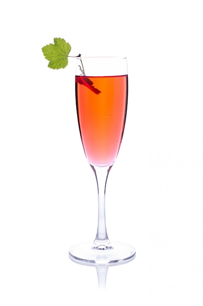 Bebida roja o cóctel en una copa de champán aislado en blanco con grosella roja
