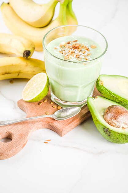 Bebida saludable de verano, batido de aguacate y plátano con lima, granola y leche de coco