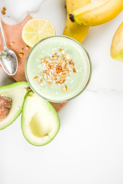 Bebida saludable de verano, batido de aguacate y plátano con lima, granola y leche de coco