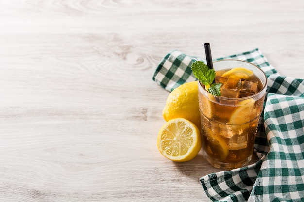 Bebida de té helado con limón en vaso y hielo