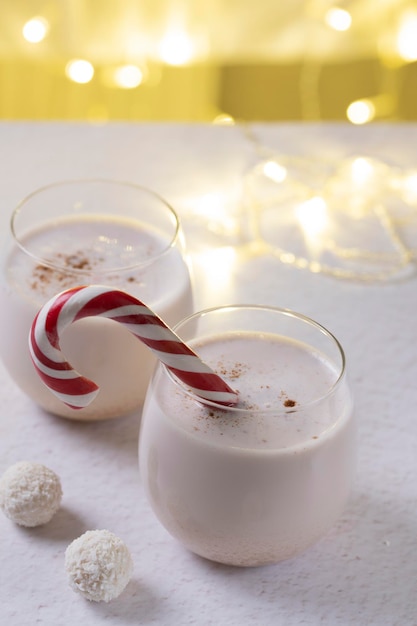 Bebida tradicional de ponche de huevo navideño hecha de huevos crudos sobre un fondo claro de garland