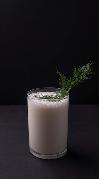 Bebida tradicional turca o de Azerbaiyán Ayran o Kefir eneldo en un vaso sobre una mesa de madera sobre un fondo negro Bebida de leche fermentada para dieta Copiar espacio el concepto de nutrición saludable