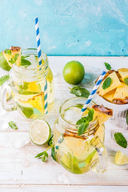 Bebida tropical mojito de abacaxi ou limonada com limão fresco e hortelã fundo azul claro