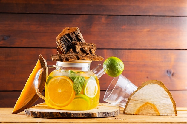 Bebida de verano de hojas de agua, limón, naranja y menta sobre tablas de madera. Té helado de lima y menta y trozos de madera. Composición creativa