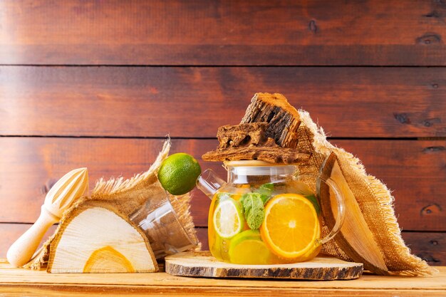 Bebida de verano de hojas de agua, limón, naranja y menta sobre tablas de madera