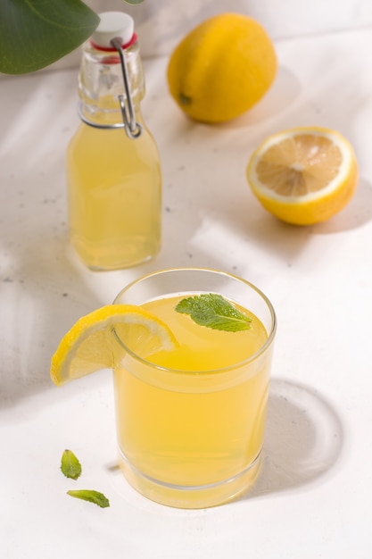 Bebida de verano limonada de kombucha fermentada junto a un limón. Foto vertical