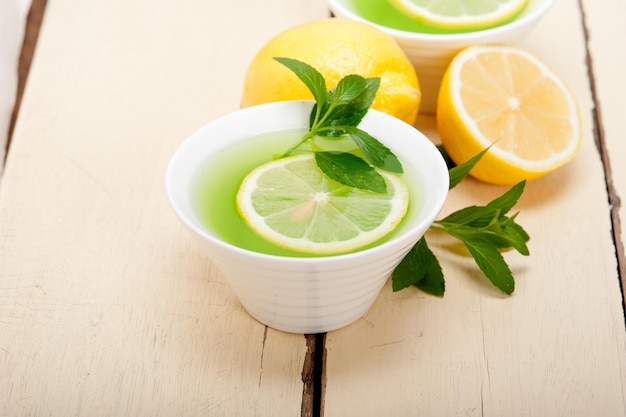 Bebida verde com limões na mesa