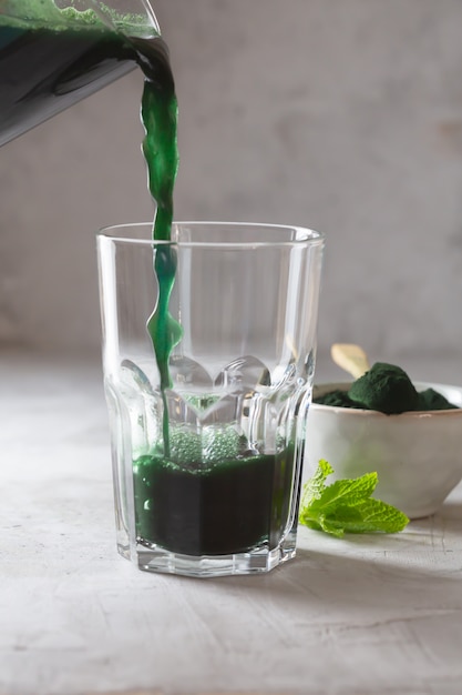 Bebida verde preparada con chlorella de algas verdes unicelulares. Súper alimento desintoxicante en el vaso