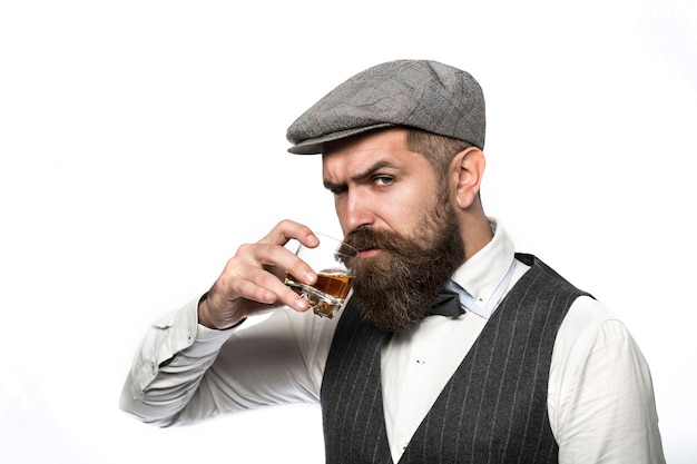 Bebida de whisky, brandy, coñac. Hombre barbudo brutal con vaso de whisky, brandy, coñac.