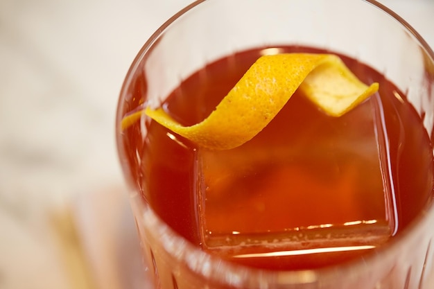 bebidas alcoólicas e conceito de luxo - close-up de vidro com coquetel de laranja no bar