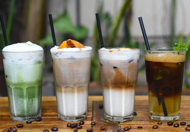 Bebidas de café con granos de café en una mesa de madera en una cafetería.