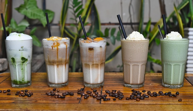 Bebidas de café con granos de café en una mesa de madera en una cafetería.