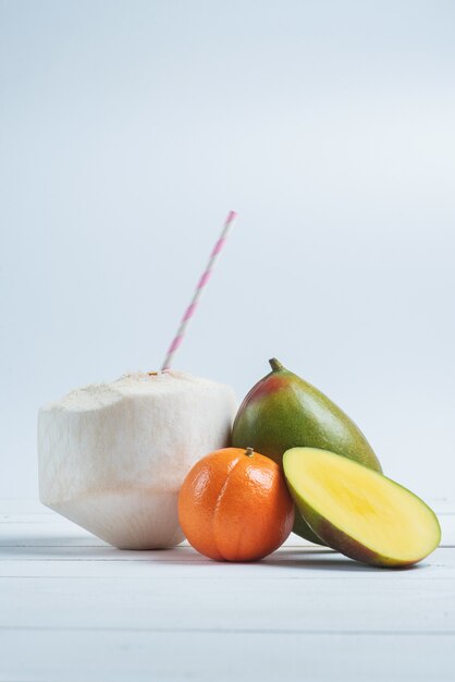 Bebidas de coco con paja, mango y mandarina.