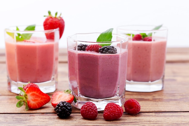 Bebidas de Berry e morango, amora, framboesa na mesa de madeira.