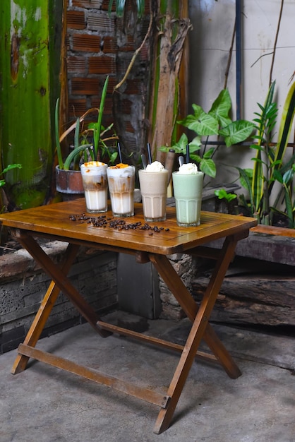 Bebidas de café com grãos de café na mesa de madeira em uma cafeteria