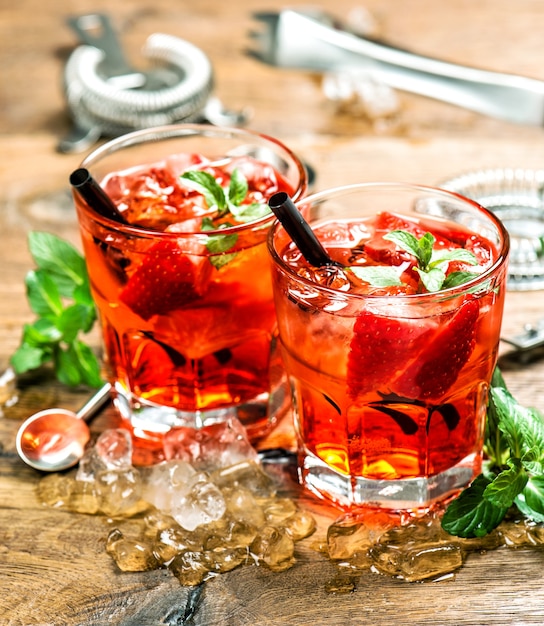 Bebidas de festa com gelo e suco. coquetel fazendo ferramentas de bar, morango, folhas de hortelã