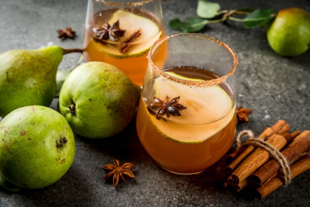 Bebidas de outono. vinho com canela. cocktail tradicional de outono picante com calda de pera, cidra e chocolate, com canela, anis, açúcar mascavo. na mesa de pedra preta. copyspace