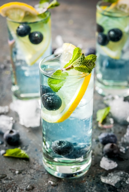 Bebidas de refresco de verão, limonada de mirtilo ou mojito cocktail com limão, mirtilos frescos e hortelã, copyspace de pedra azul sdark