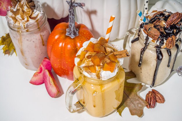 Bebidas de smoothie de torta de maçã, abóbora e noz-pecã. Conjunto de coquetéis com sabor de bolo assado no outono tradicional, no espaço de cópia de fundo branco