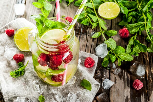 Bebidas de verão, coquetéis. Comida vegana. Água de desintoxicação com infusão de limão, hortelã e framboesas orgânicas frescas