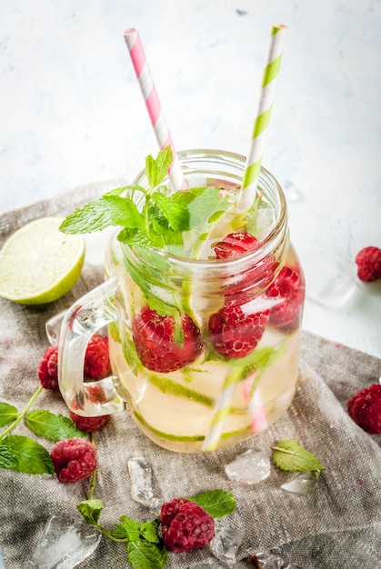 Bebidas de verão, coquetéis. Comida vegana. Água de desintoxicação com infusão de limão, hortelã e framboesas orgânicas frescas