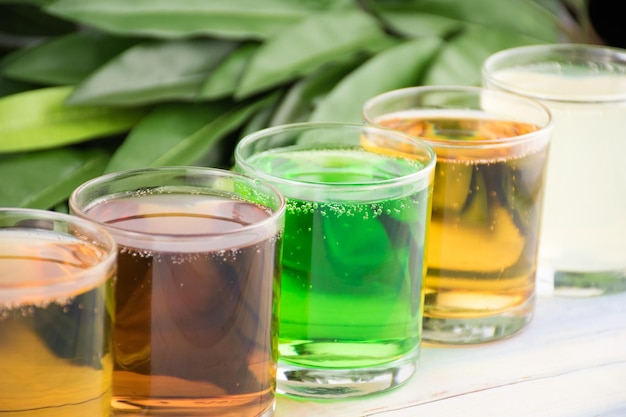 Foto bebidas doces coloridas brilhantes soda e coquetéis em copos estão seguidos