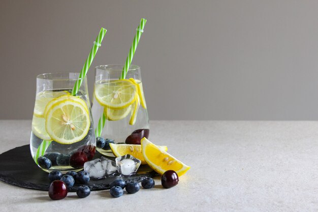 bebidas frías en botellas pequeñas cerezas y limón limonada mojito cóctel bebida helada de verano